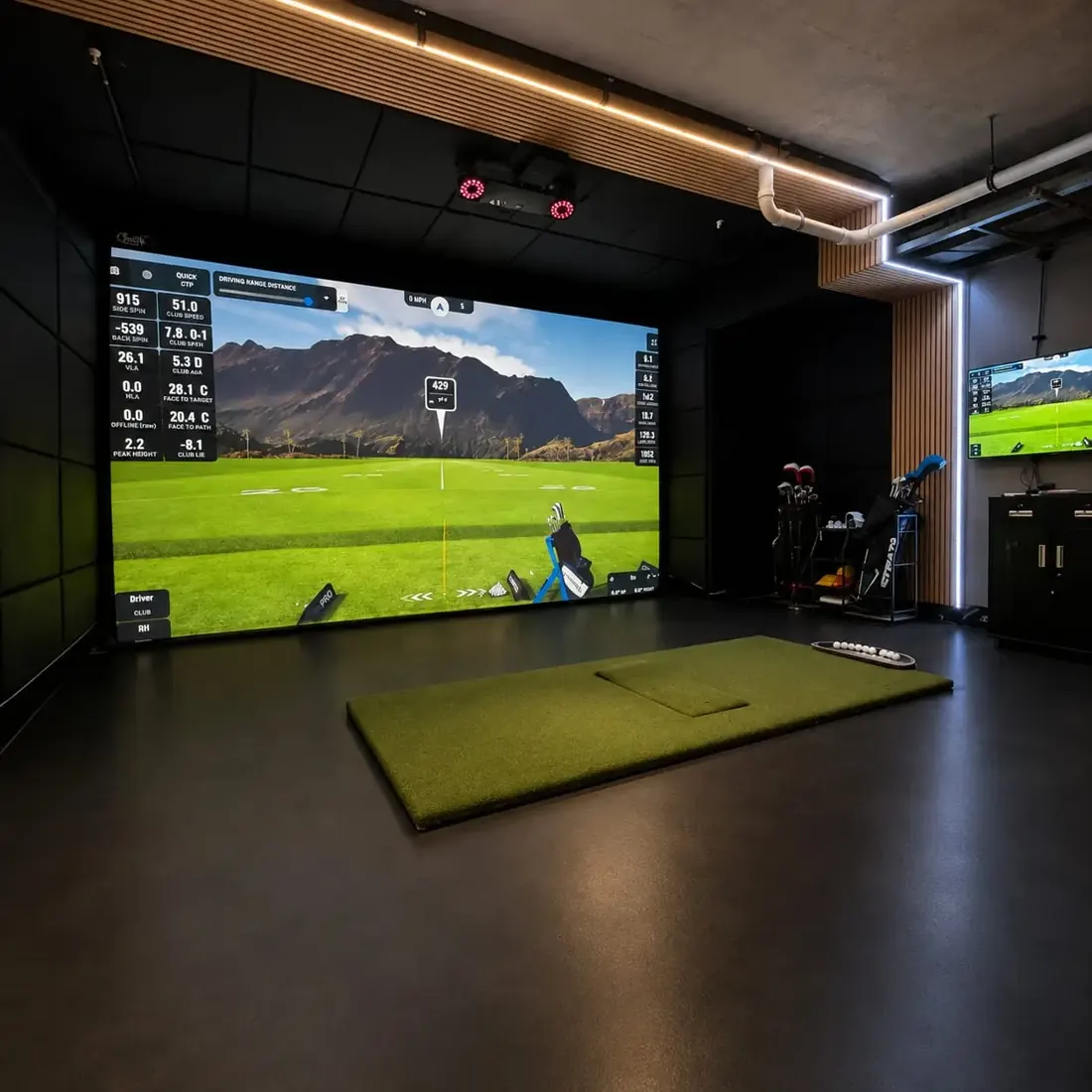 Golf simulator bay with black padded panels on the walls